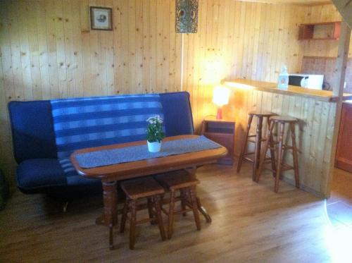 斯瓦热沃Domki Mantras的客厅配有蓝色的沙发和桌子