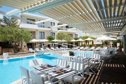 卡尼奥提卡尼奥提文艺复兴度假公寓式酒店的游泳池旁设有桌子和白色椅子的游泳池