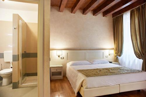 维罗纳马赞蒂酒店的一间卧室设有一张大床和一个卫生间