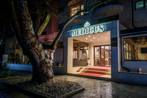 沃尔舍茨SPA Hotel Medicus的商店前有树的建筑物