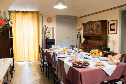 皮亚扎-阿尔梅里纳B&B L'Angelica的用餐室配有长桌,提供食物