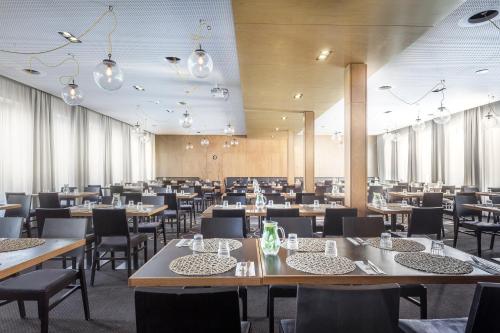 布拉格Hotel Golf Prague的大型用餐室配有桌椅