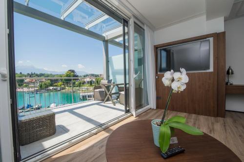 沃尔特湖畔韦尔登Boutiquehotel Wörthersee - Serviced Apartments的客厅设有桌子和大窗户