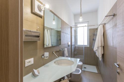 圣维托罗卡波Hotel Tannure的一间带水槽、卫生间和镜子的浴室