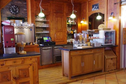 琴山朗勒堡克雷德尚酒店的厨房配有木制橱柜和带酒吧的柜台。
