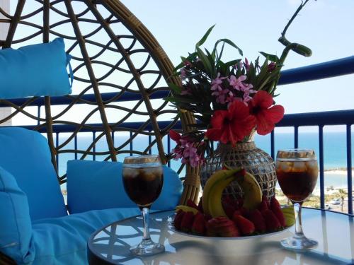 亚实基伦Avrora Luxury Apartment的一张桌子,上面放着两杯葡萄酒和鲜花