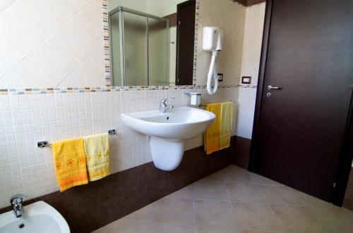 萨萨里拉波尔塔阿坎图B&B酒店的一间带水槽、镜子和卫生间的浴室