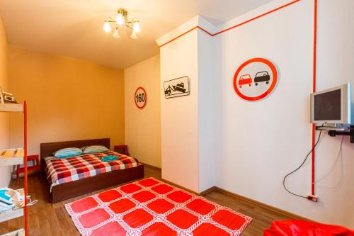 符拉迪沃斯托克VVO中心公寓的一间卧室配有一张床和红色地毯