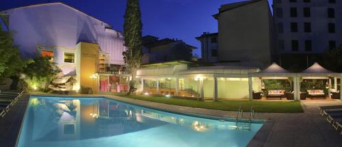 蒙特卡蒂尼泰尔梅阿杜亚丽晶娜萨巴康体美容酒店的夜间在房子前面的游泳池