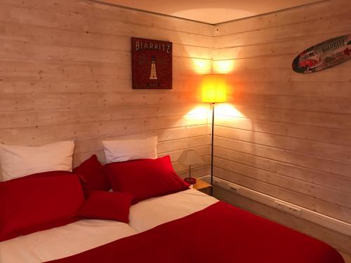 比亚里茨切斯菲多姆住宿加早餐旅馆的一间卧室配有一张带红色枕头和一盏灯的床