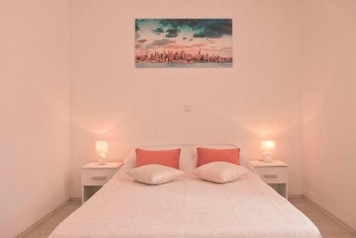 卡利Apartment Suha的白色卧室配有带两盏灯的床