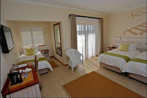 斯瓦科普蒙德Stay @ Swakop的酒店客房,配有两张床和椅子