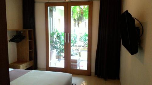 勒吉安库布卡里克酒店的卧室设有滑动玻璃门,可通往庭院。