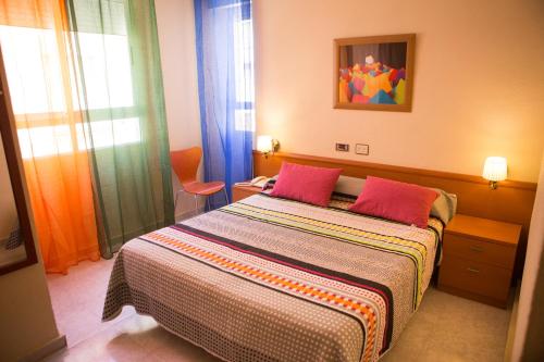 圣地亚哥德拉里贝拉马德里酒店的一间卧室配有一张带两个红色枕头的床