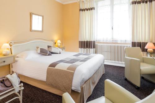 欧里亚克托马瑟之家酒店的配有一张床和一把椅子的酒店客房