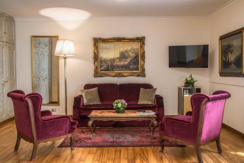 罗马论坛酒店的客厅配有沙发和两把椅子