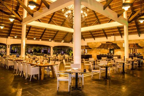 普拉亚伯尼塔村Dreams Playa Bonita All Inclusive的大楼内带桌椅的用餐室