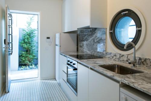 波尔图波尔图服务式公寓 - 阿尔瓦莱卡布拉尔的厨房配有水槽和镜子