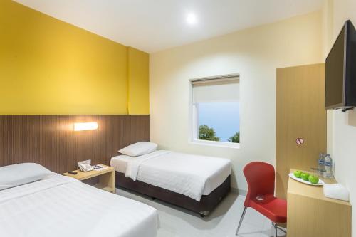 塞尔蓬宾塔罗阿斯特拉酒店的酒店客房,设有两张床和一张红色椅子