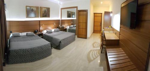 乌贝拉巴Tamareiras Prime Hotel的酒店客房设有两张床和电视。