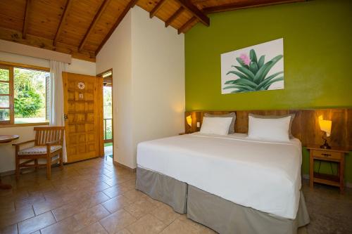 阿蒂巴亚帕约尔宾馆的卧室配有白色的床和绿色的墙壁