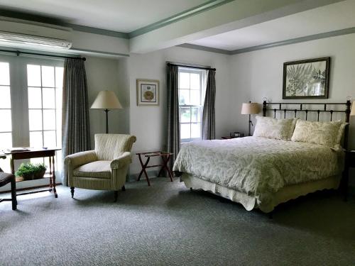 旧莱姆老莱姆宾馆的一间卧室配有一张床、一把椅子和窗户。