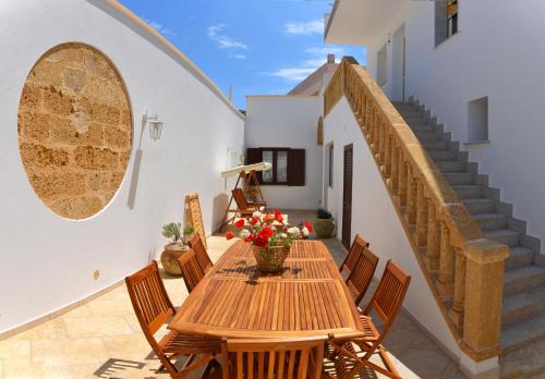 莫尔恰诺迪莱乌卡B&B Anemos的庭院设有木桌和椅子,设有楼梯