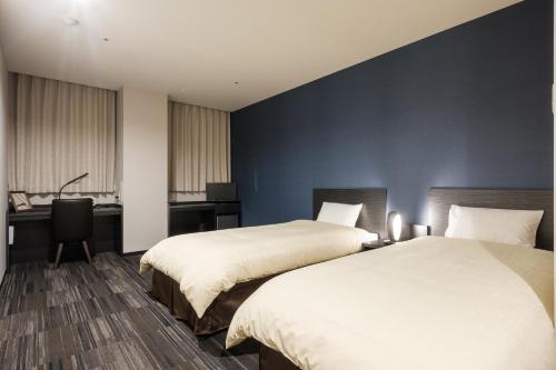 泉佐野瑞库高级酒店的酒店客房配有两张床和一张书桌
