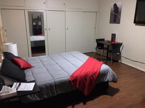 德尼利昆爱德华河酒店的一间卧室配有一张床铺,床上铺有红色毯子