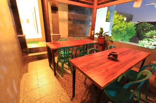 库塔瑟雅酒店的餐厅设有两张木桌和绿色椅子