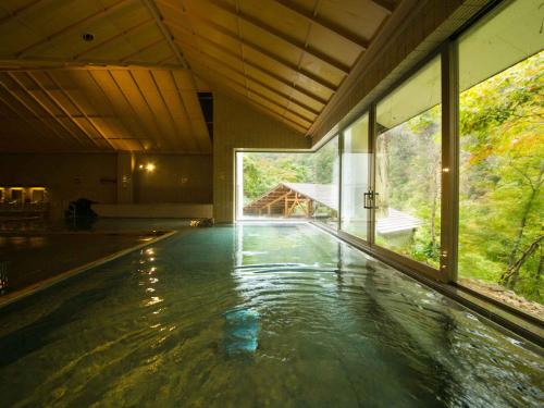 会津若松Ookawaso的一座带大窗户的房子里的一个空游泳池