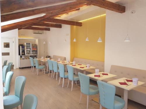的里雅斯特罗马酒店的一间配备有桌子和蓝色椅子的用餐室