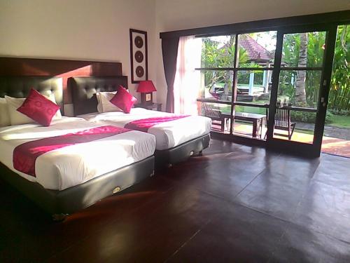 努沙杜瓦D'Mell Bali的一间卧室设有两张床和大窗户