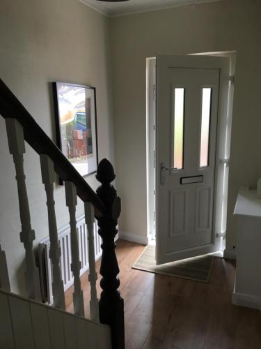 贝尔法斯特Belfast Holiday Home的一条带白色门和楼梯的走廊