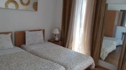 蒙蒂茹阿罗门托切萨里尼酒店的一间小卧室,配有两张床和镜子
