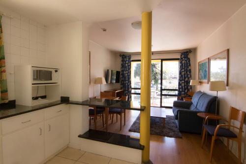 丰沙尔Apartamentos Turisticos Avenue Park的厨房以及带桌椅的起居室。