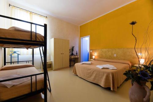 切奇纳Il彭特酒店的一间卧室设有两张双层床和黄色的墙壁