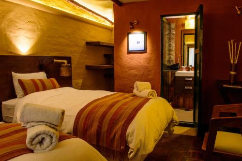 乌尤尼花园乌尤尼酒店的一间带两张床的卧室和一间带水槽的浴室