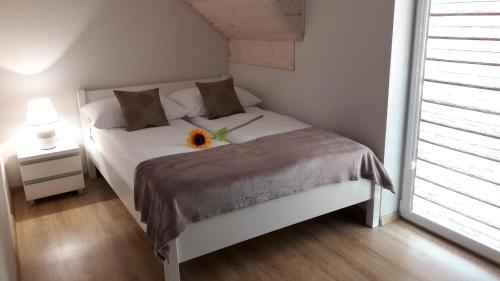 尤斯托尼莫斯基Domki Marina的卧室配有一张白色的床,上面有向日葵