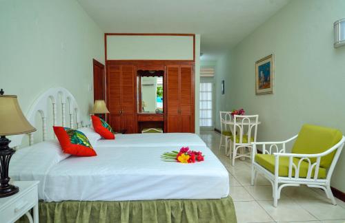 基督教堂市多佛海滩酒店的一间卧室配有两张床和鲜花椅子