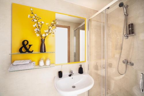 潘普洛纳Camplus Pamplona的浴室配有盥洗盆和带镜子的淋浴