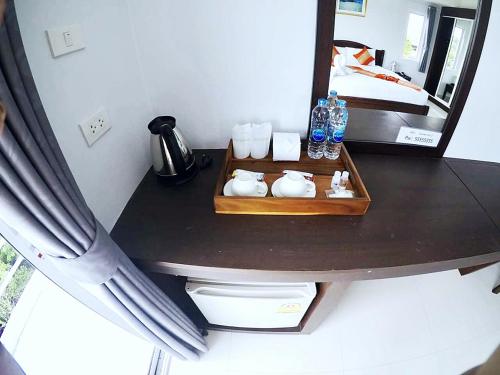甲米镇日出宾馆的一张桌子和一张镜子,一张桌子和一张床上的镜子