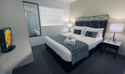 凯恩斯凯恩斯酒店的一间卧室配有一张大床和电视
