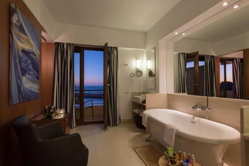 干尼亚Porto Veneziano Hotel的一间带大浴缸和大镜子的浴室