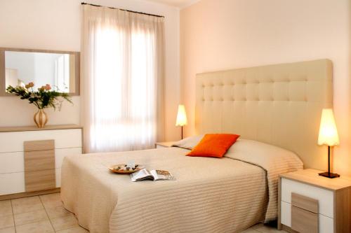 卡斯蒂里昂纳·德拉佩Residence Teclini的卧室配有一张白色大床和镜子