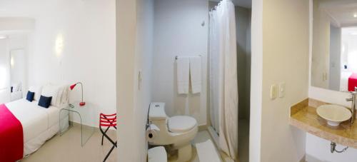 卡塔赫纳萨尔梅迪纳酒店的白色的浴室设有一张床和淋浴。
