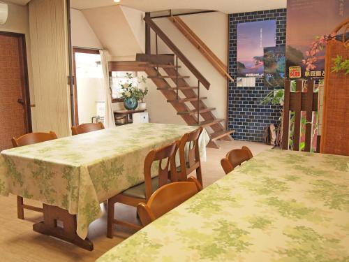 土庄町喜久屋日式旅馆的一间带两张桌子和楼梯的用餐室