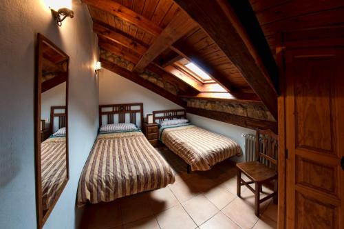 Portilla de la ReinaEl Invernal de Picos的配有木天花板的客房内的两张床