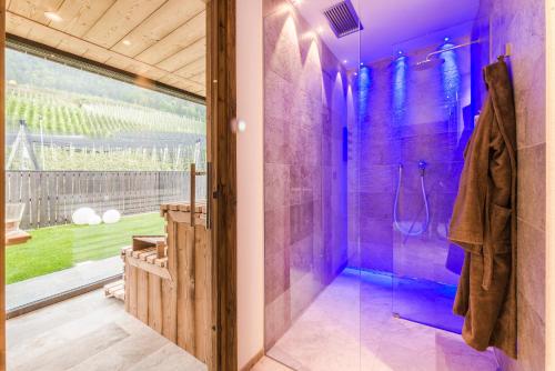沃兰Hotel Restaurant Kirchsteiger的带淋浴的紫色浴室和玻璃门