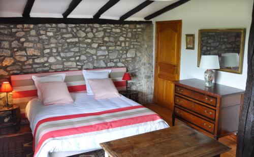 西布勒Chambres d'hôtes Gela Itsasoa Océan的一间卧室设有一张床和石墙